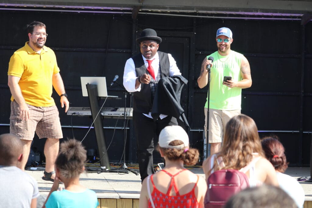 Summer camp director and children enjoying professional family entertainment at an Indianapolis camp event
