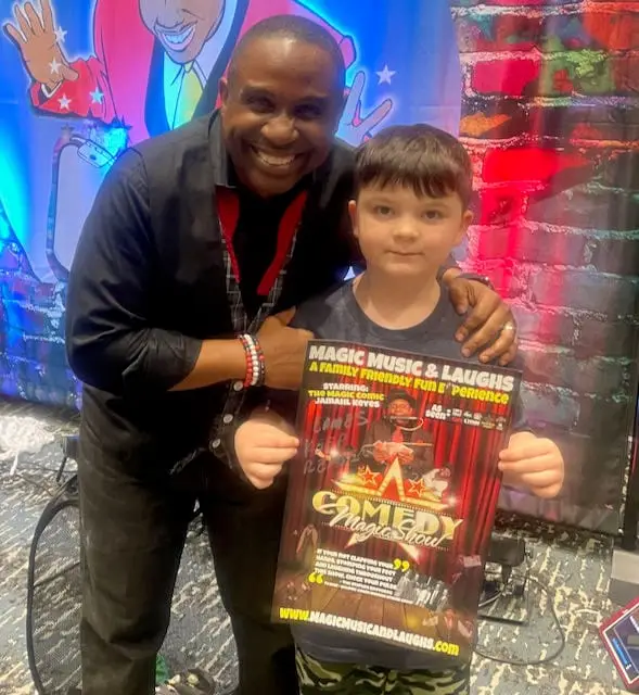 Jamahl Keyes, The Magic Comic, smiling with a 10-year-old birthday child after performing his comedy magic show in Carmel, Indiana.