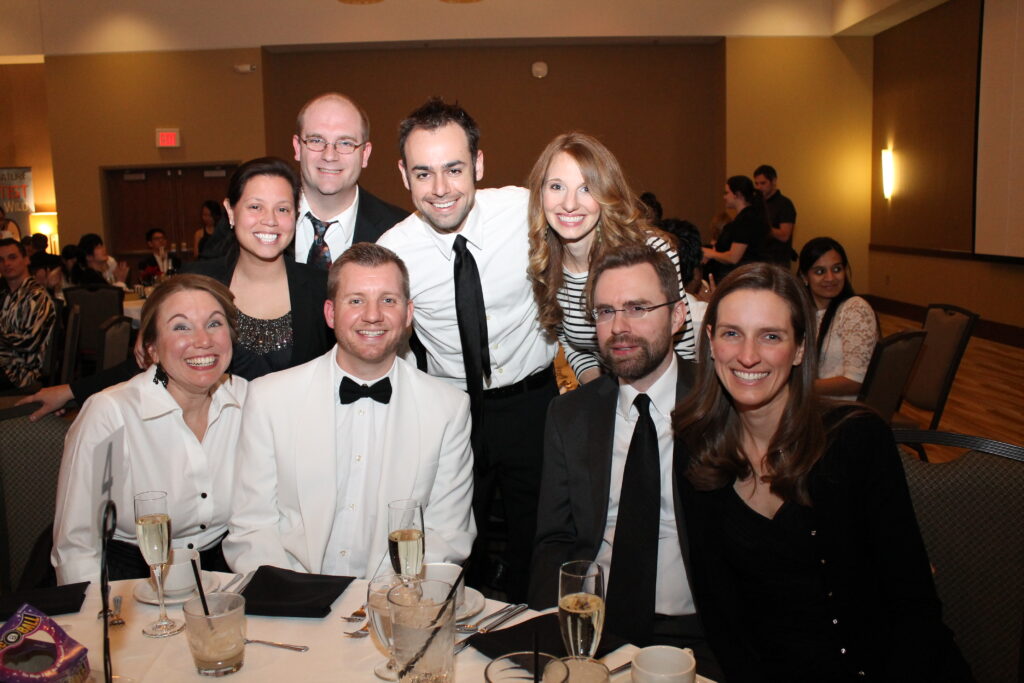 Tom and Lisa celebrating their 50th birthday in Carmel, Indiana with magician Jamahl Keyes and guests smiling after an unforgettable comedy magic show.