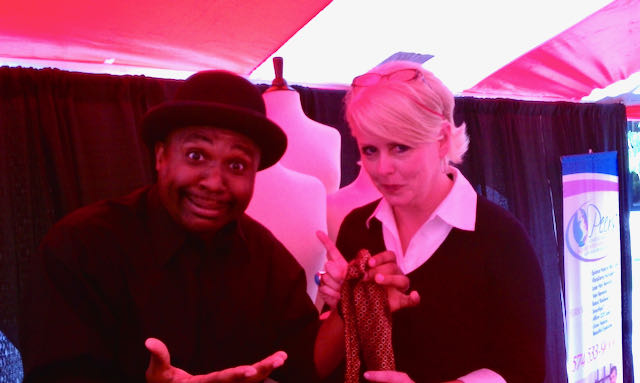 The Magic Comic Jamahl Keyes shares a laugh with Project Runway’s Peach Carr backstage at the Indianapolis Convention Center as she helps him choose a tie before hosting the runway show.