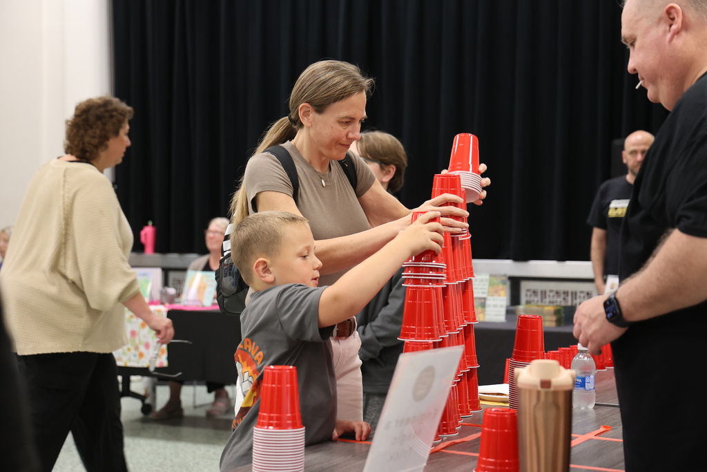 Close up side view of elementary school students smiling and laughing during an educational comedy magic show for a Warren Township school family night event.