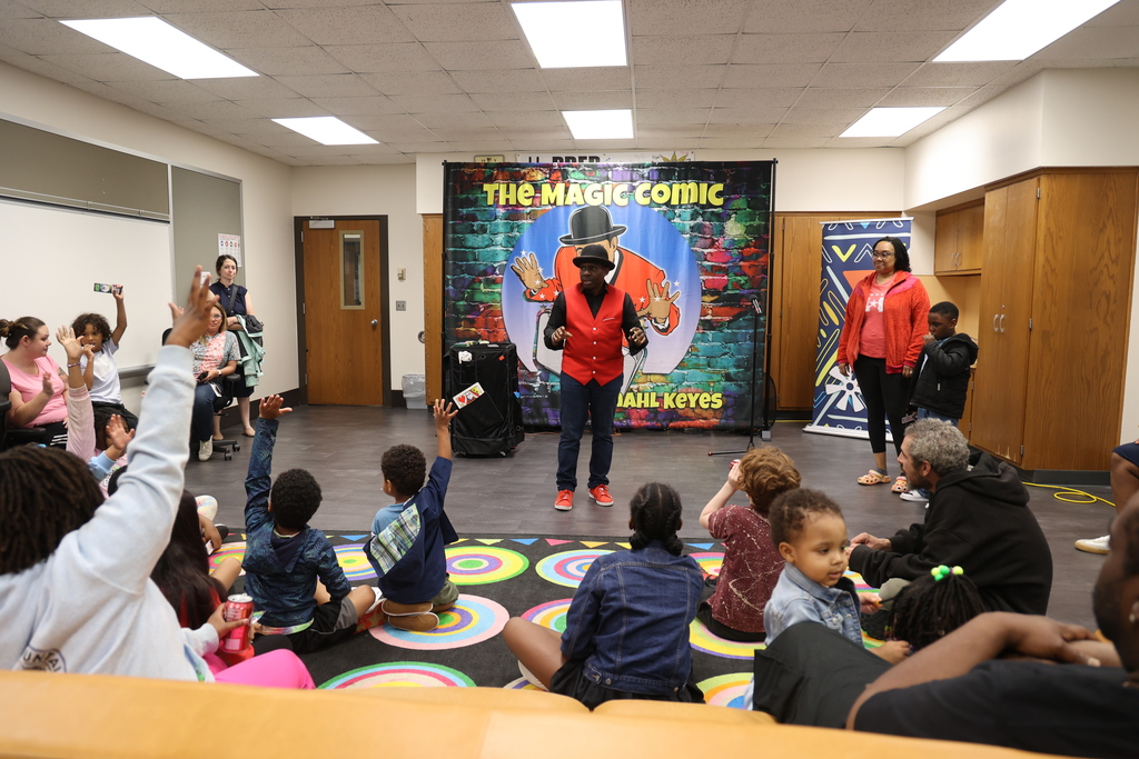 Indianapolis magician Jamahl Keyes performing an interactive science illusion on stage with an elementary student volunteer during the A Night of Wonder school assembly program.
